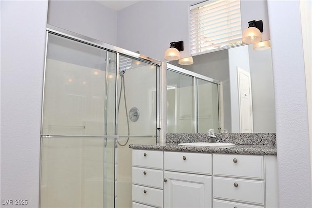 bathroom featuring vanity and a shower with door