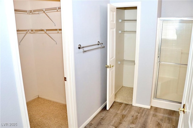 bathroom featuring wood-type flooring and a shower with shower door