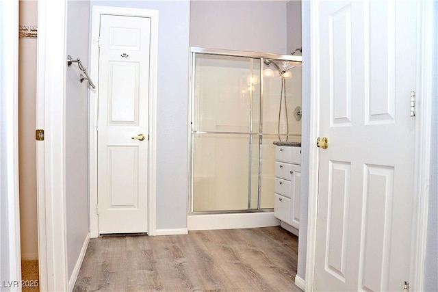 bathroom with hardwood / wood-style flooring and a shower with door