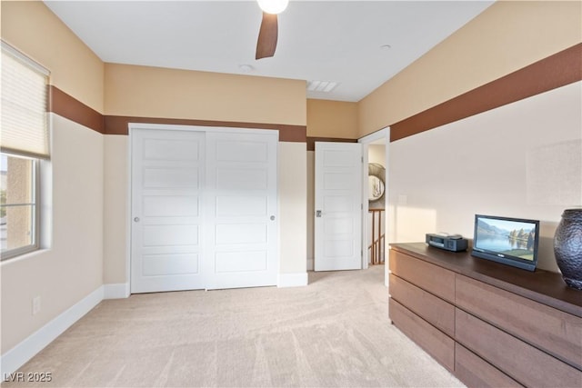 bedroom with ceiling fan, a closet, and light carpet