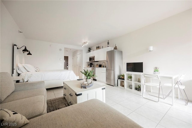 tiled bedroom with stainless steel fridge, a closet, and vaulted ceiling