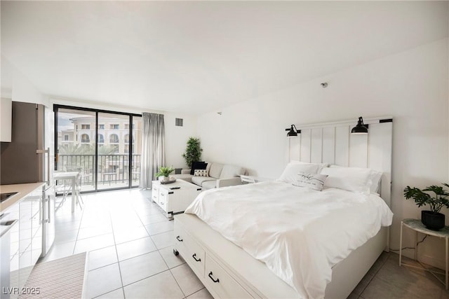 tiled bedroom with floor to ceiling windows and access to exterior