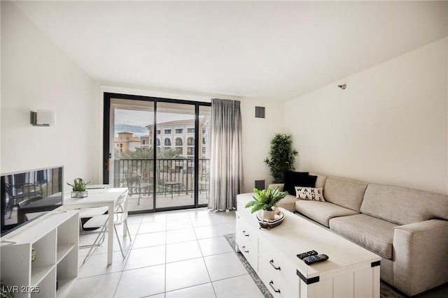 living room with floor to ceiling windows and light tile patterned floors