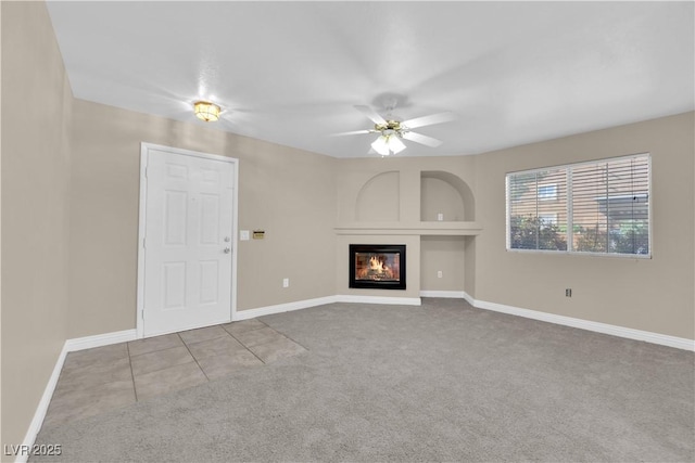 unfurnished living room featuring light colored carpet and ceiling fan