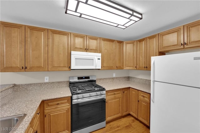 kitchen featuring white appliances, light hardwood / wood-style floors, and sink