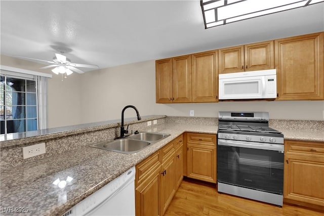 kitchen featuring sink, white appliances, ceiling fan, light hardwood / wood-style floors, and kitchen peninsula