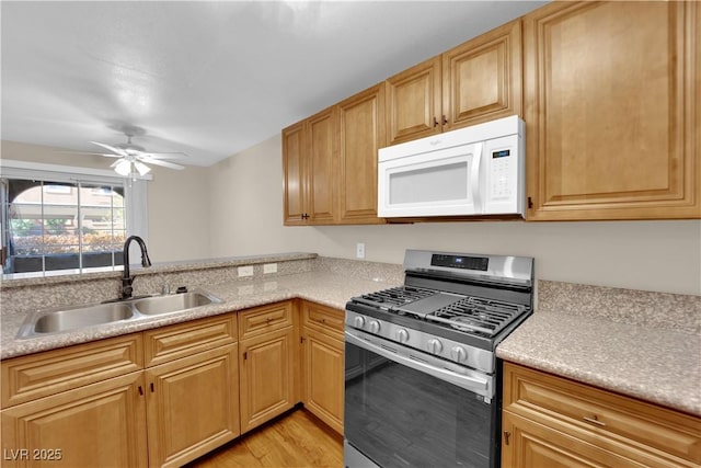 kitchen with sink, light hardwood / wood-style floors, gas stove, and ceiling fan