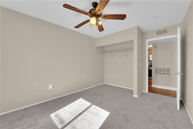 unfurnished bedroom with ceiling fan, light colored carpet, and a closet