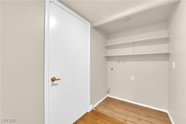 clothes washing area with wood-type flooring and hookup for a gas dryer