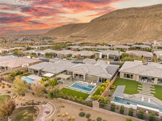 aerial view at dusk featuring a mountain view