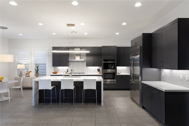 kitchen featuring pendant lighting, stainless steel appliances, a breakfast bar, and a center island with sink