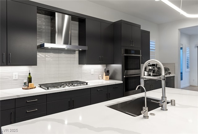 kitchen with appliances with stainless steel finishes, sink, decorative backsplash, and wall chimney exhaust hood