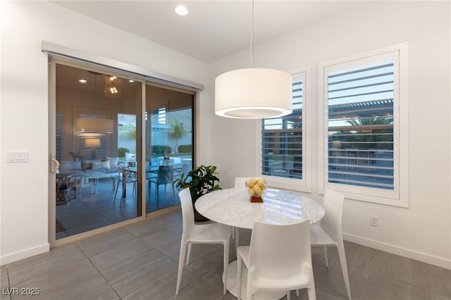 dining area with dark tile patterned floors and a healthy amount of sunlight