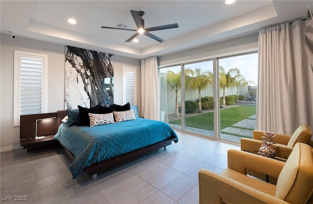 bedroom featuring ceiling fan, a raised ceiling, light tile patterned floors, and access to outside