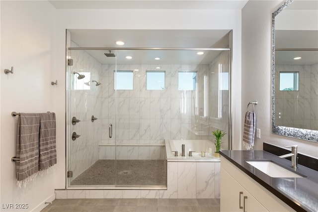 bathroom featuring independent shower and bath, vanity, and a wealth of natural light