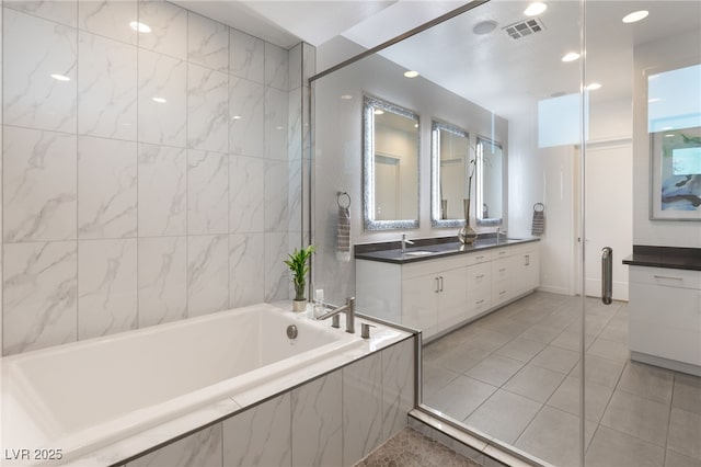 bathroom featuring vanity, tiled tub, and tile patterned floors