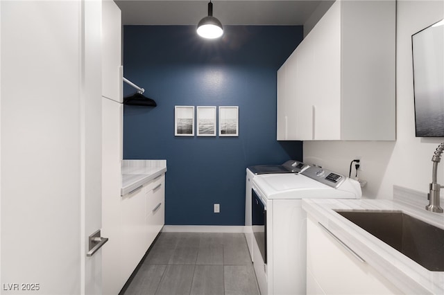 laundry room with cabinets, light tile patterned flooring, separate washer and dryer, and sink