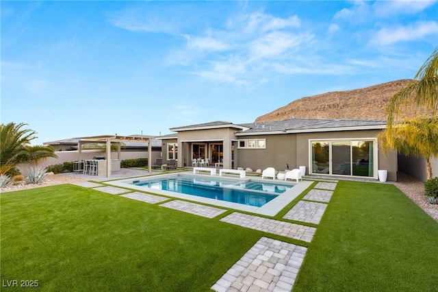 rear view of property featuring a lawn, a patio, and an outdoor bar