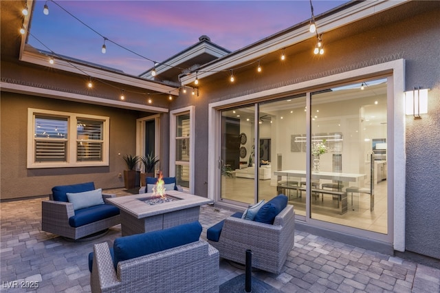 patio terrace at dusk featuring an outdoor living space with a fire pit