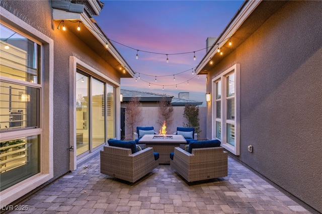 patio terrace at dusk featuring an outdoor living space with a fire pit