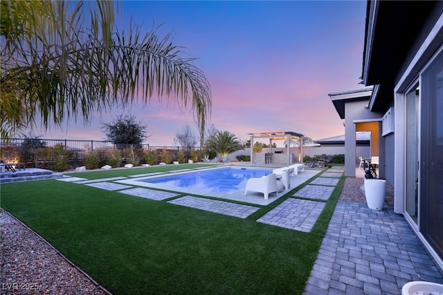 pool at dusk featuring a pergola, a patio area, and a lawn