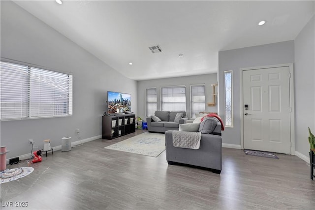 living room featuring lofted ceiling and light hardwood / wood-style floors