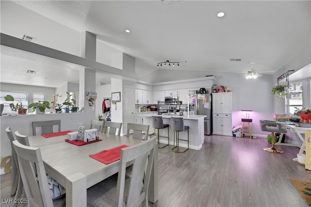 dining area featuring light hardwood / wood-style flooring, vaulted ceiling, and ceiling fan