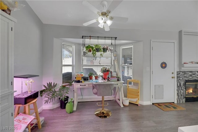 dining room with hardwood / wood-style floors, a fireplace, and ceiling fan