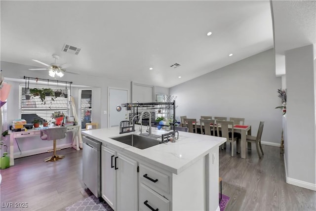 kitchen featuring sink, white cabinetry, light wood-type flooring, dishwasher, and a kitchen island with sink