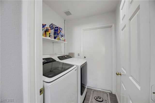 clothes washing area with light hardwood / wood-style flooring and washing machine and dryer