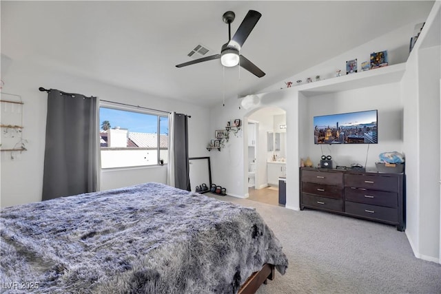 bedroom with ceiling fan, lofted ceiling, connected bathroom, and light carpet