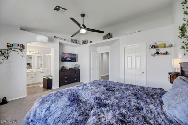 bedroom featuring ceiling fan, connected bathroom, and light carpet