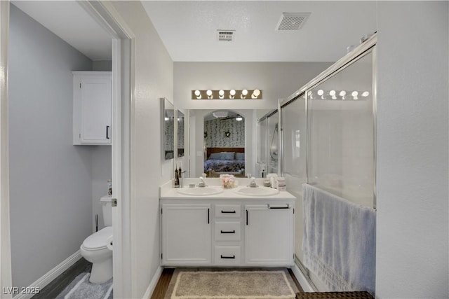 bathroom with vanity, hardwood / wood-style flooring, a shower with shower door, and toilet