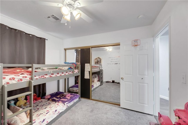 carpeted bedroom featuring ceiling fan and a closet