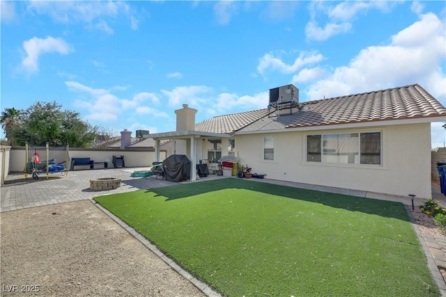 rear view of house featuring a patio area, central air condition unit, and an outdoor fire pit