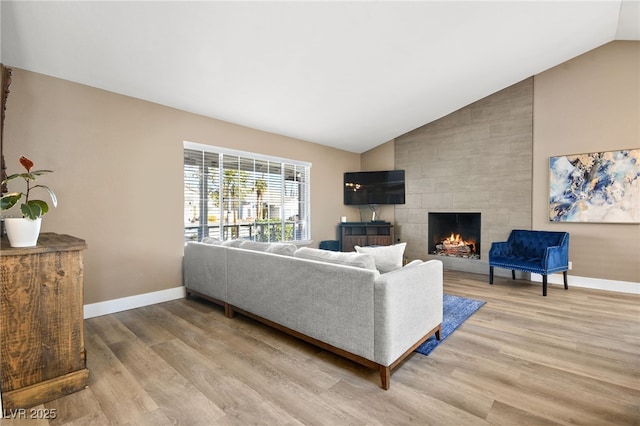 living room featuring lofted ceiling, hardwood / wood-style floors, and a fireplace