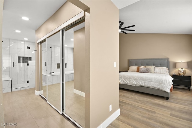 bedroom featuring ceiling fan, ensuite bathroom, and light wood-type flooring