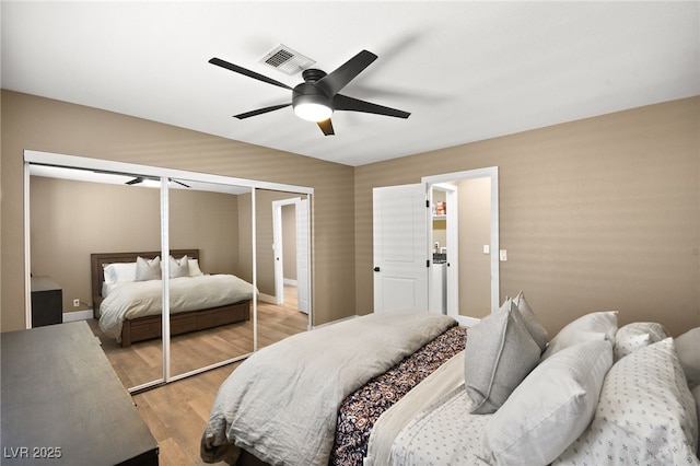 bedroom with ceiling fan, light wood-type flooring, and a closet