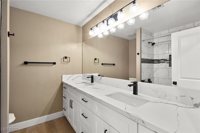 bathroom featuring tiled shower, vanity, and hardwood / wood-style floors