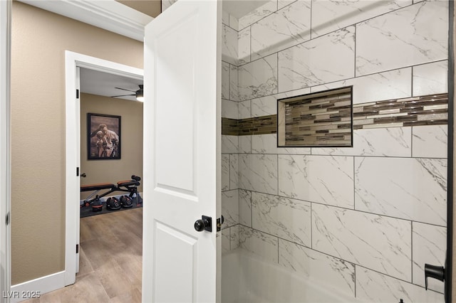 bathroom with ceiling fan, wood-type flooring, and tiled shower / bath combo