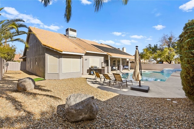 rear view of house featuring cooling unit, a fenced in pool, and a patio