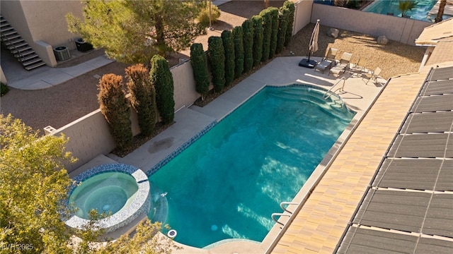 view of swimming pool featuring an in ground hot tub and a patio area