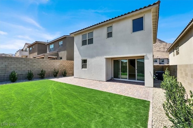 rear view of house featuring a patio and a lawn