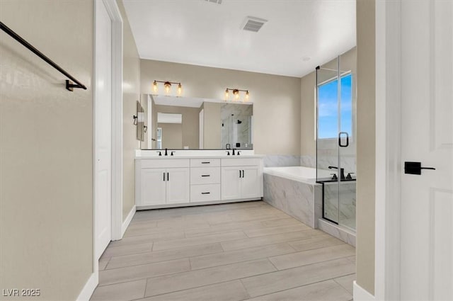 bathroom with independent shower and bath and vanity