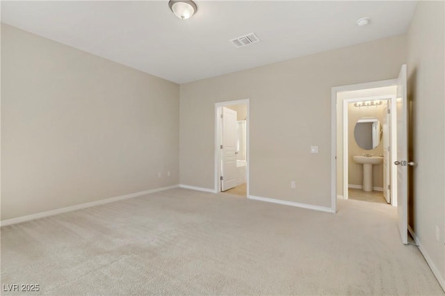 unfurnished bedroom featuring connected bathroom and light colored carpet