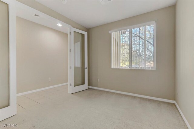 unfurnished bedroom with light carpet and french doors