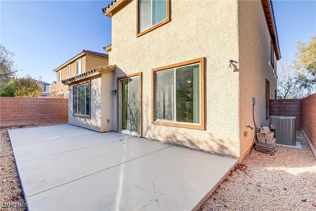 rear view of house with central AC and a patio area