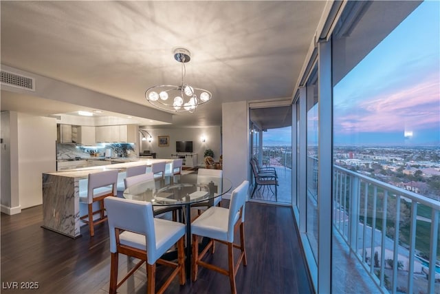 dining space with expansive windows, dark hardwood / wood-style floors, and a chandelier