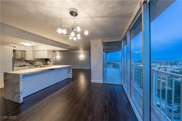 kitchen with dark wood-type flooring, white cabinetry, kitchen peninsula, pendant lighting, and decorative backsplash