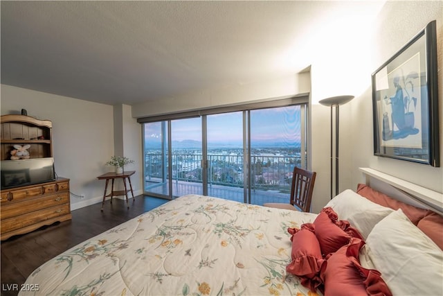 bedroom with a textured ceiling, access to exterior, and dark hardwood / wood-style flooring